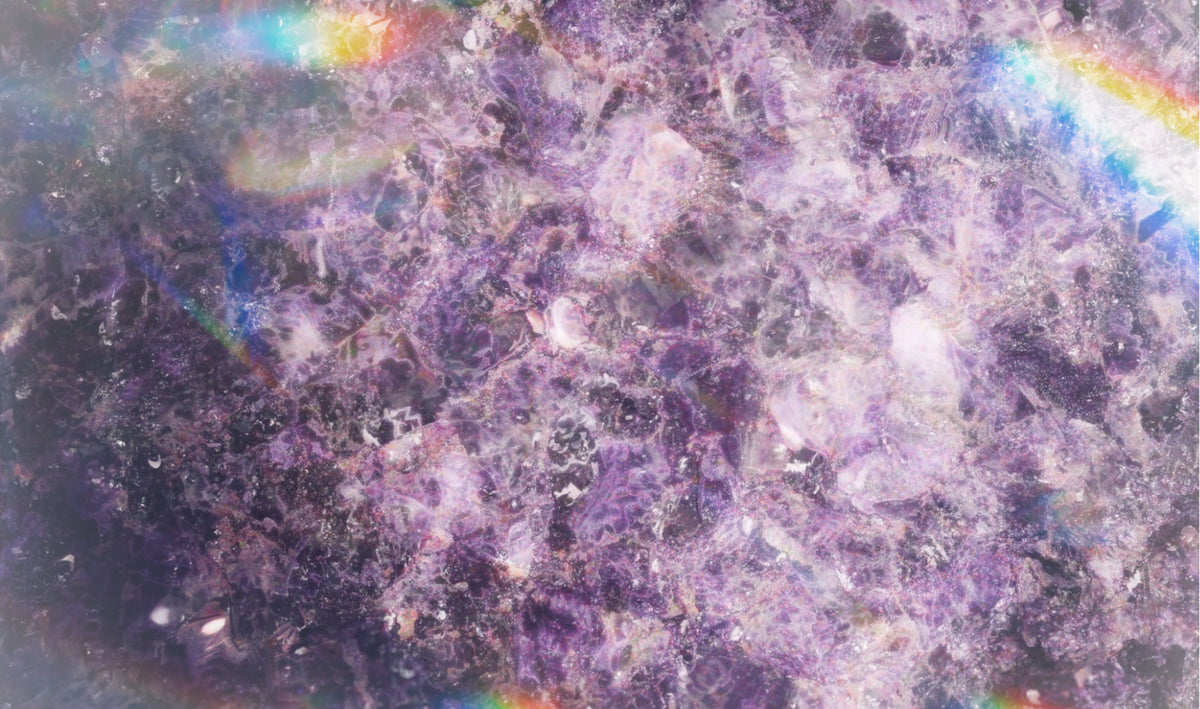  Extreme close-up of illuminated amethyst stone showing rich purple crystal structure, translucent mineral depth, and glowing internal light.
