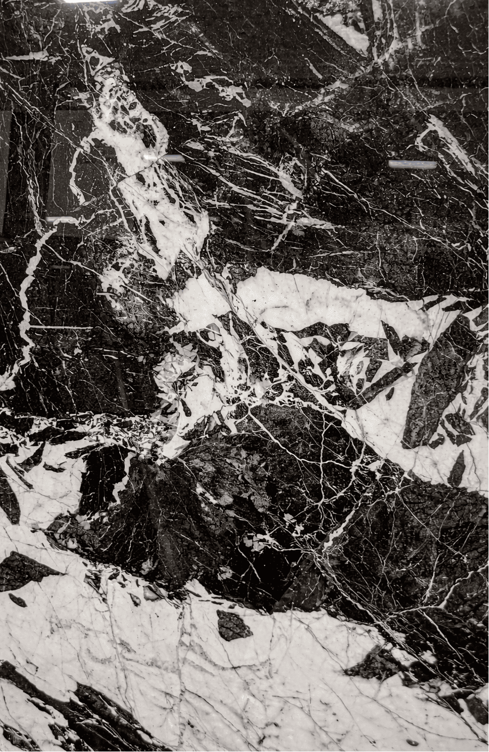 Close-up of Noir Grand Antique marble with dramatic black and white fractured veining
